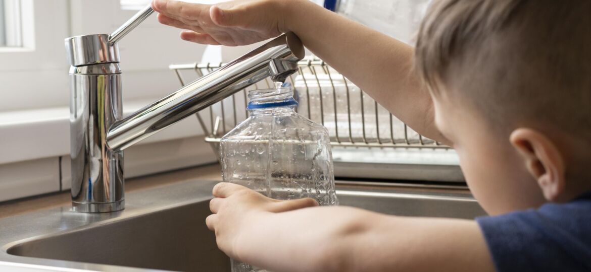 close-up-kid-filling-bottle-with-water