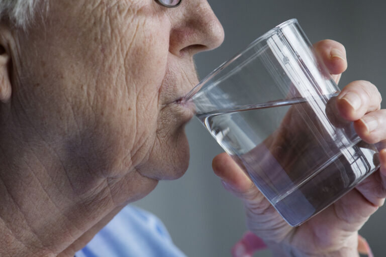 Side view of elderly woman drinking water