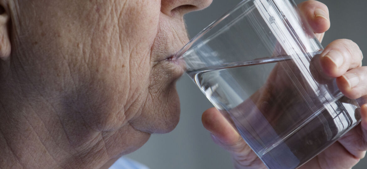 Side view of elderly woman drinking water